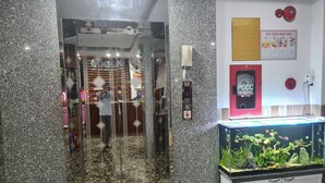 An elevator with a digital display, a fire hose reel, and a fish tank. - Anh Vy Hotel (Quy Nhon Nam)