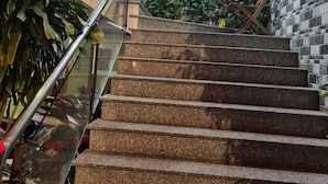 A staircase with granite steps, glass railings, and potted plants. - Anh Vy Hotel (Quy Nhon Nam)