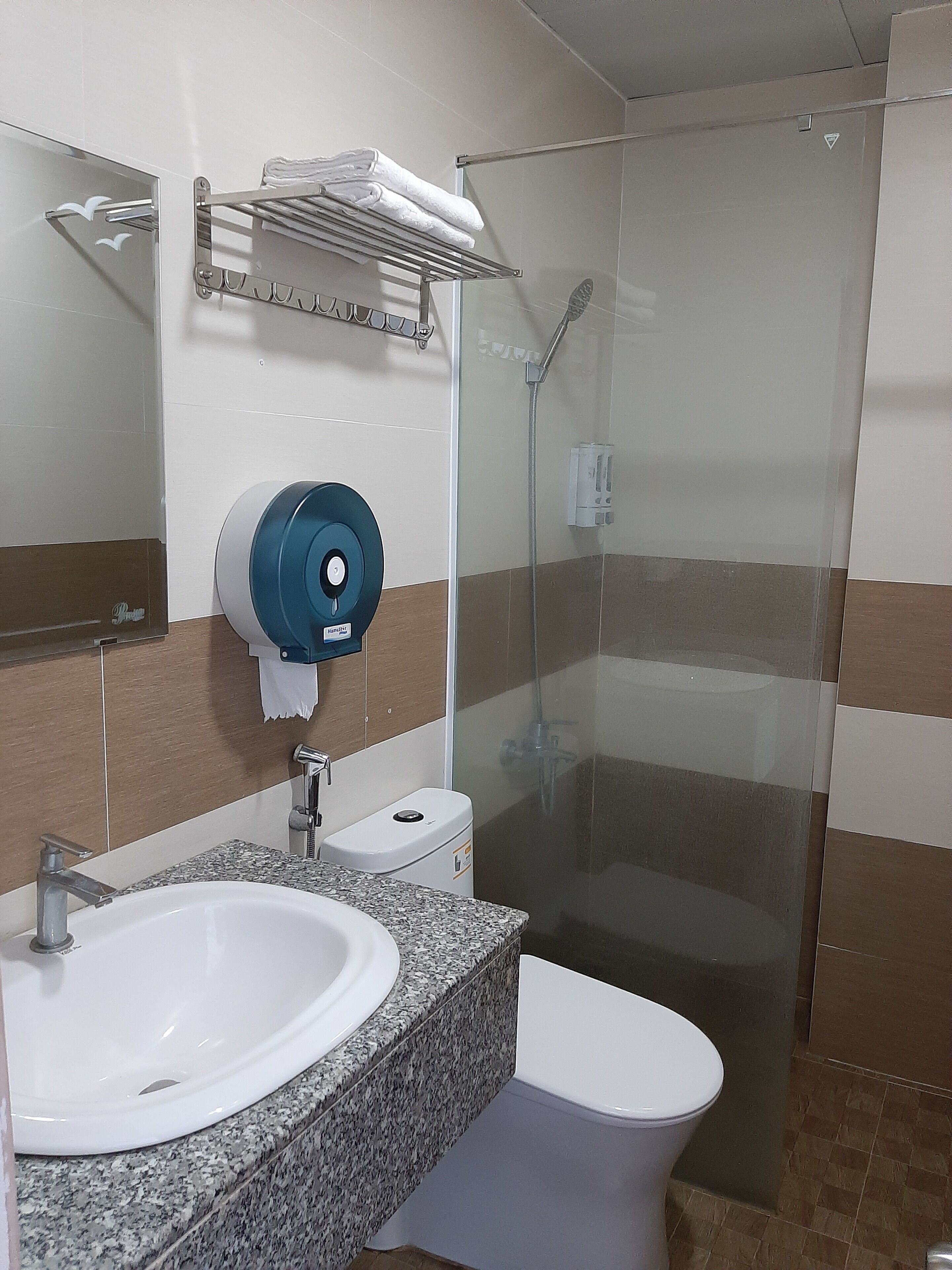 Un baño con lavabo, inodoro y ducha con cerramiento de vidrio.