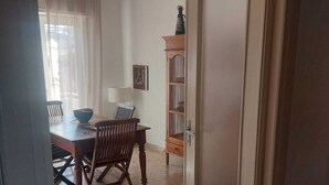 Een eethoek met een houten tafel en stoelen, een lamp en een deur met ruitverdeling.