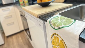 A kitchen counter with a cutting board, a bowl of fruit, and a sink. - Apartment Grand Costa Brava (Canyelles)