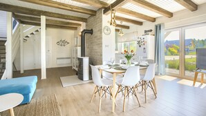 A modern kitchen with a dining area, wooden beams, and a view of the outdoors. - Apartamenty Sun & Snow Dom Cayetano (gmina Wolin)