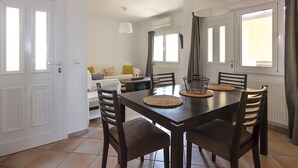 Een eetgedeelte met een donker houten tafel, zes stoelen en een hanglamp.