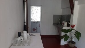 A room with a white table set with glassware and a potted plant. - Indra Sisila Villa Bentota  (Bentota)