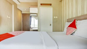 Ein Hotelzimmer mit zwei Betten, einer Tür und einem Fenster.