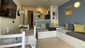 A modern living room with a sofa, a TV, a ceiling fan, and a dining area with a table and chairs. - LLORET HIGH - PREMIUM (Lloret de mar)