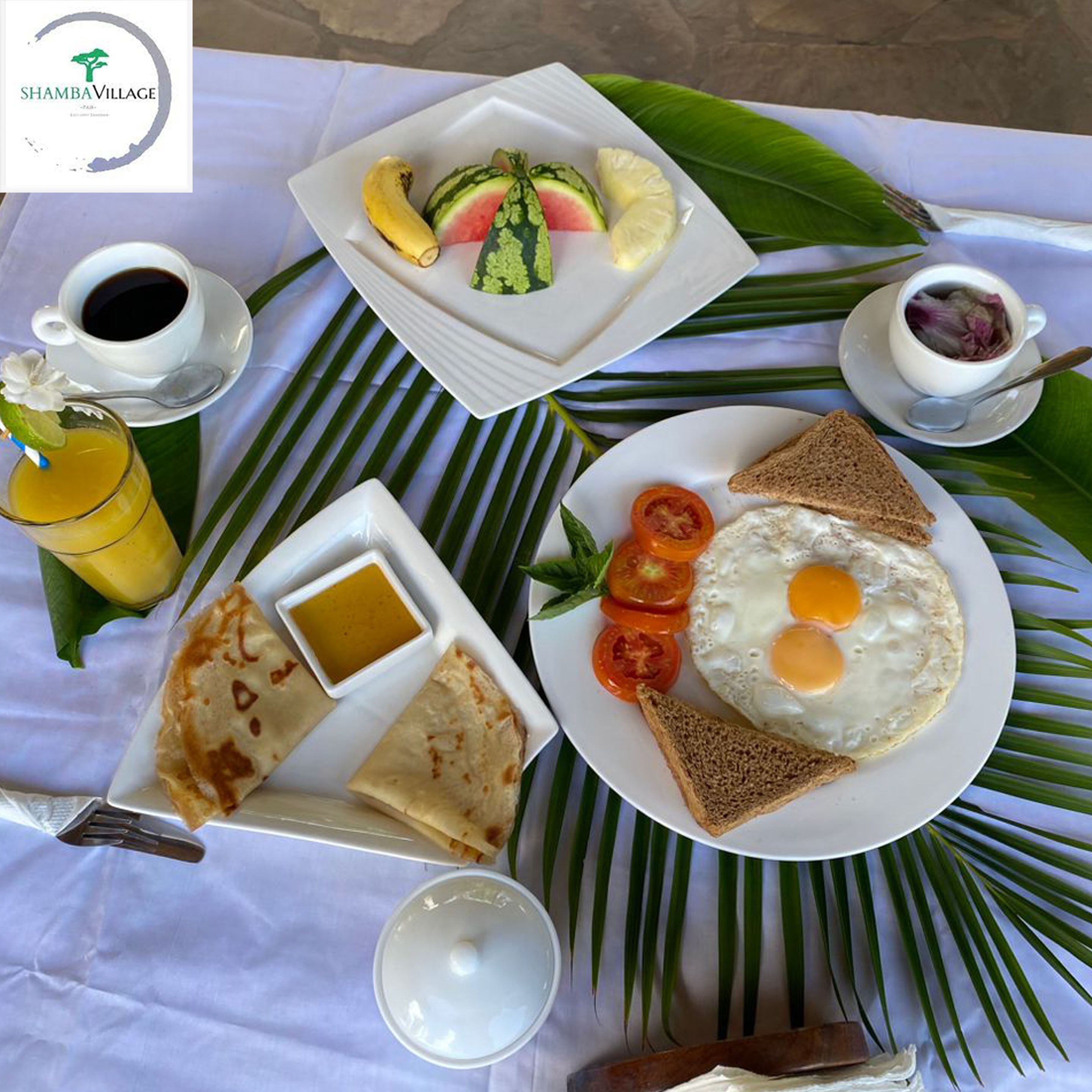 Un assortiment de mets pour le petit-déjeuner est disposé sur une table : des assiettes de toasts, des œufs, des tomates et une banane.