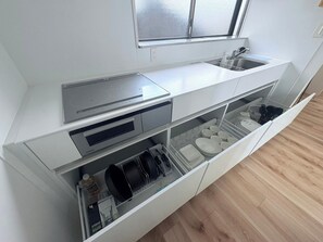 Kylskåp, mikrovågsugn, spishäll och grytor/köksredskap