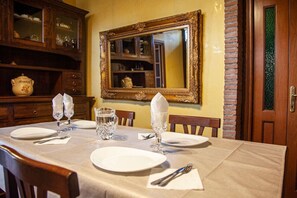 Enjoy meals in this elegant dining area with a table set for four, featuring a central vase and a large mirror.