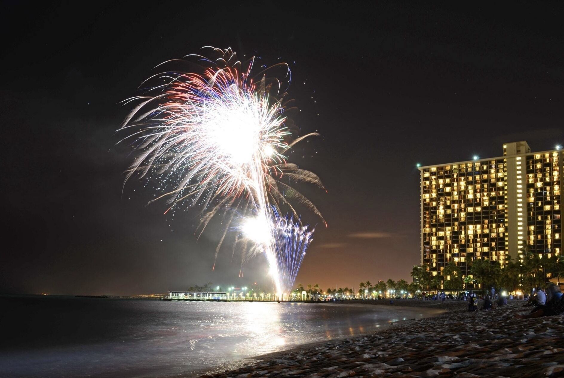 Hotel amb vistes al mar i un espectacle de focs artificials a la distància.