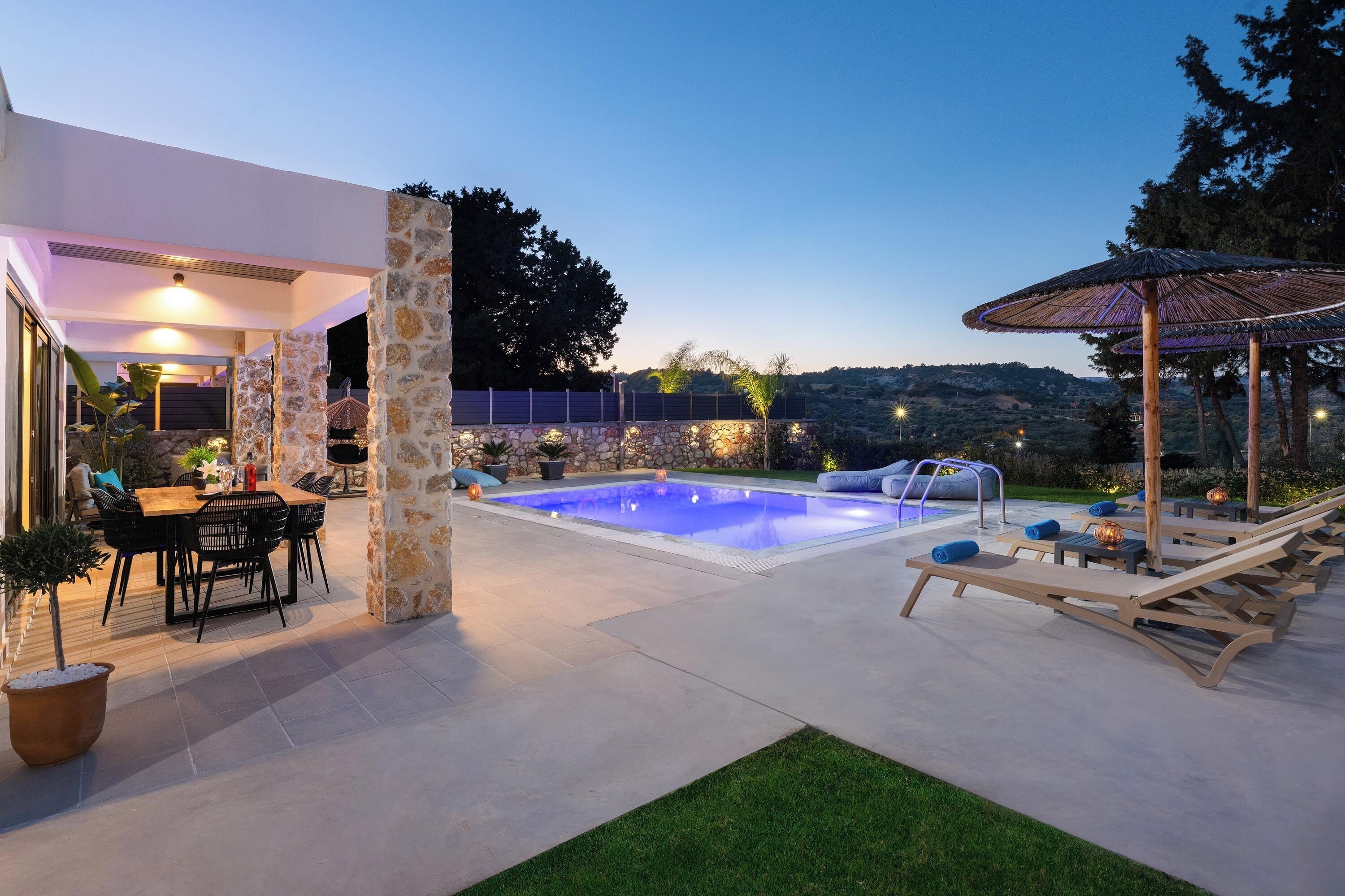 A pool area with lounge chairs, a table, and a pergola.