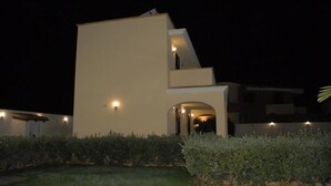 A modern building with a flat roof and a staircase leading to an upper level.