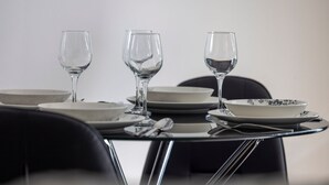 A dining table with three wine glasses, plates, and cutlery. - Edge One - Dog Friendly (Jindabyne)
