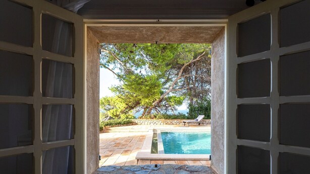 An open window with a view of a swimming pool, stone steps, and a lounge chair. - Casa Perdita, ideal for family and relaxed vacations (Deiá)