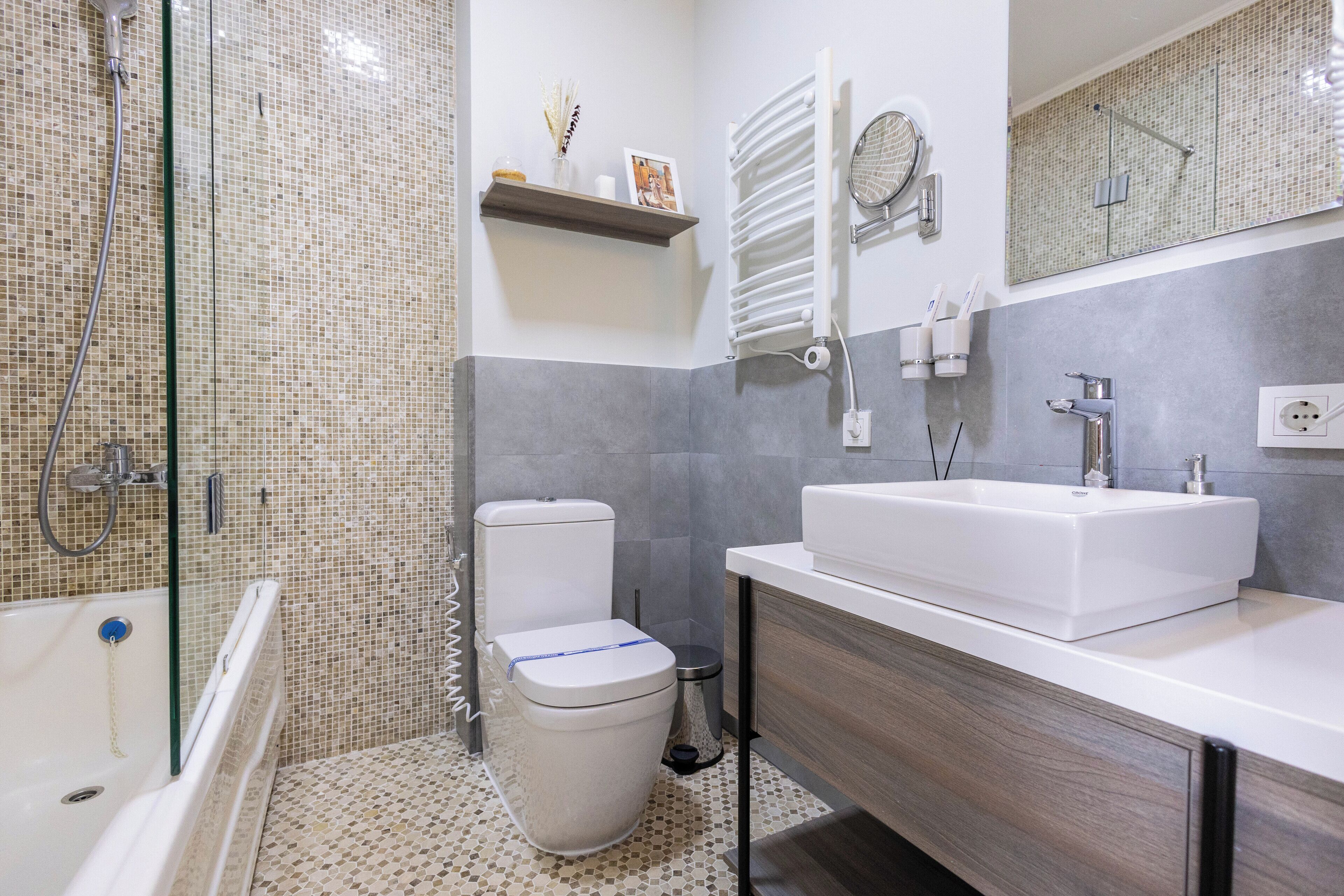 A modern bathroom with a shower, toilet, and sink.