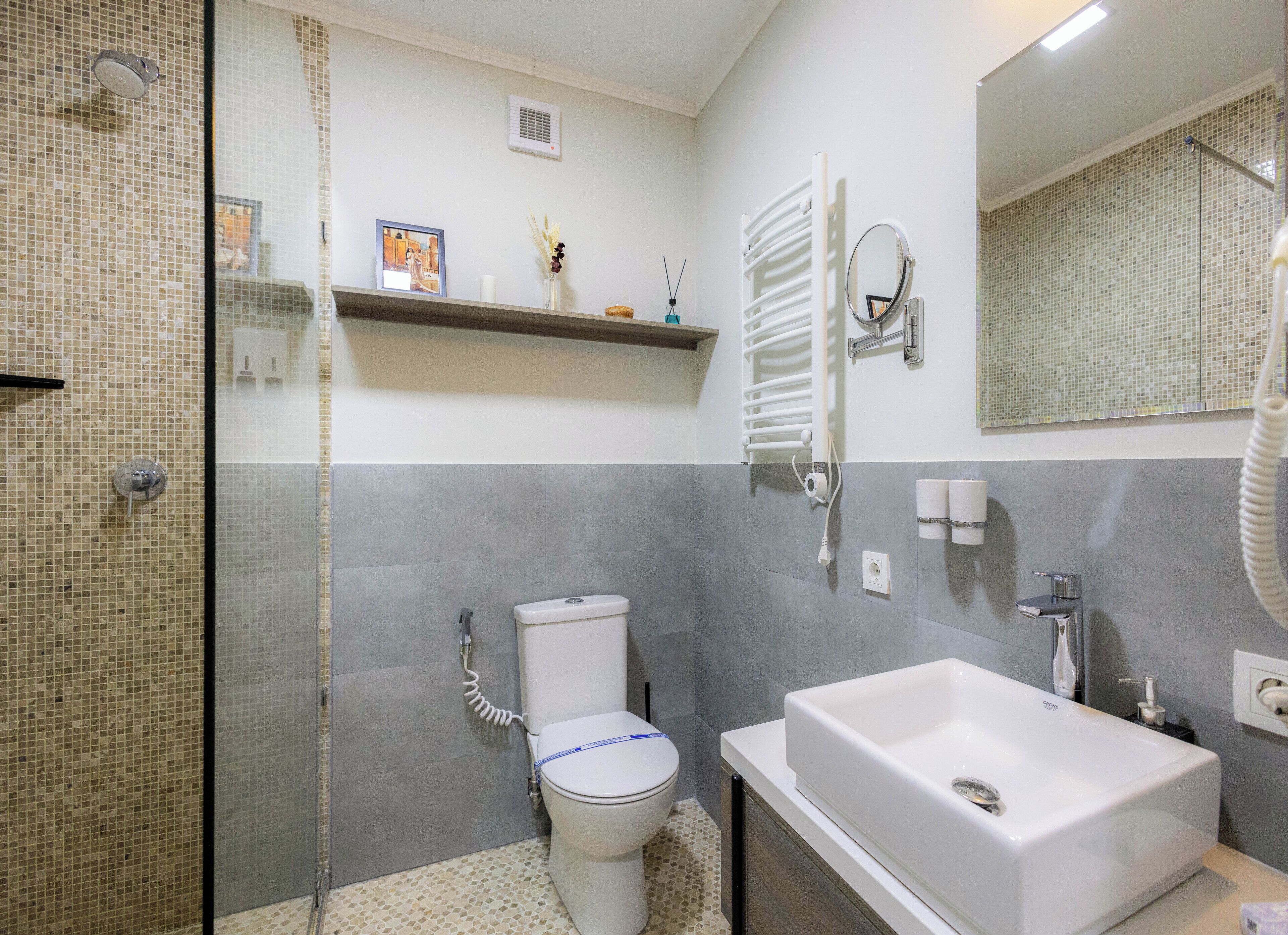 Une salle de bain moderne avec une douche à parois de verre, des toilettes, une baignoire et un meuble-lavabo avec un miroir.