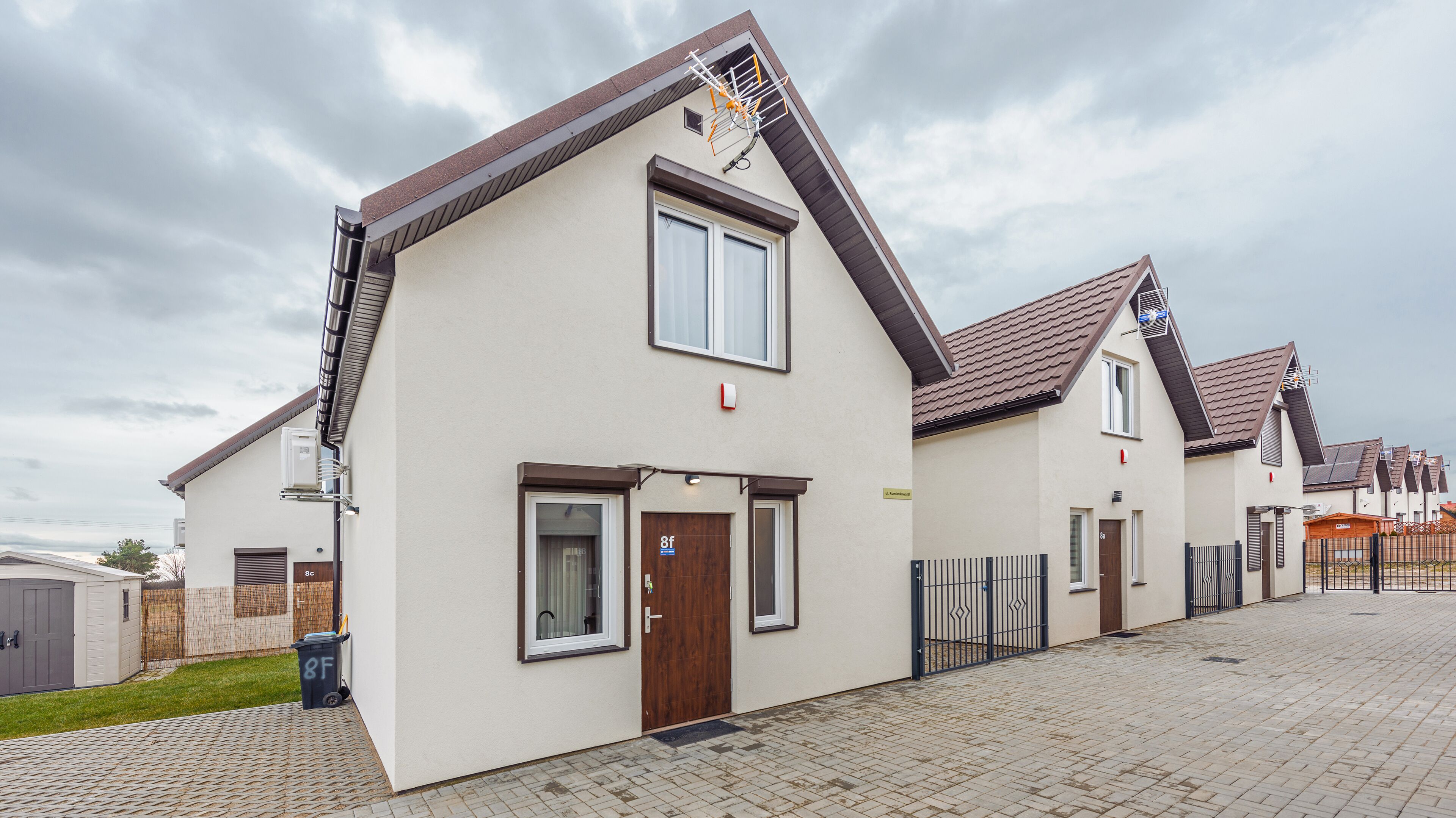 A modern residential building with a flat roof, a front door, and a small window.