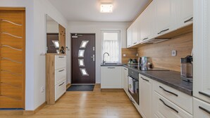 Een moderne keuken met houten kastjes, een inbouwoven en een spoelbak.
