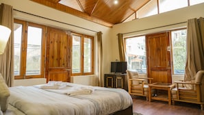 Une chambre à coucher avec un grand lit, des meubles en bois et de nombreuses fenêtres.