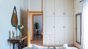 A bedroom with a bed, a wardrobe, a mirror, a desk with a vase of flowers, and a potted plant. - Άνετη βίλα οικογενειακού μεγέθους με υδρομασάζ! (Heraklion, Crete)