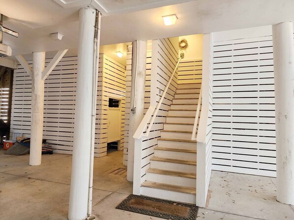 A staircase with white railings and a wooden handrail, leading to an upper floor.