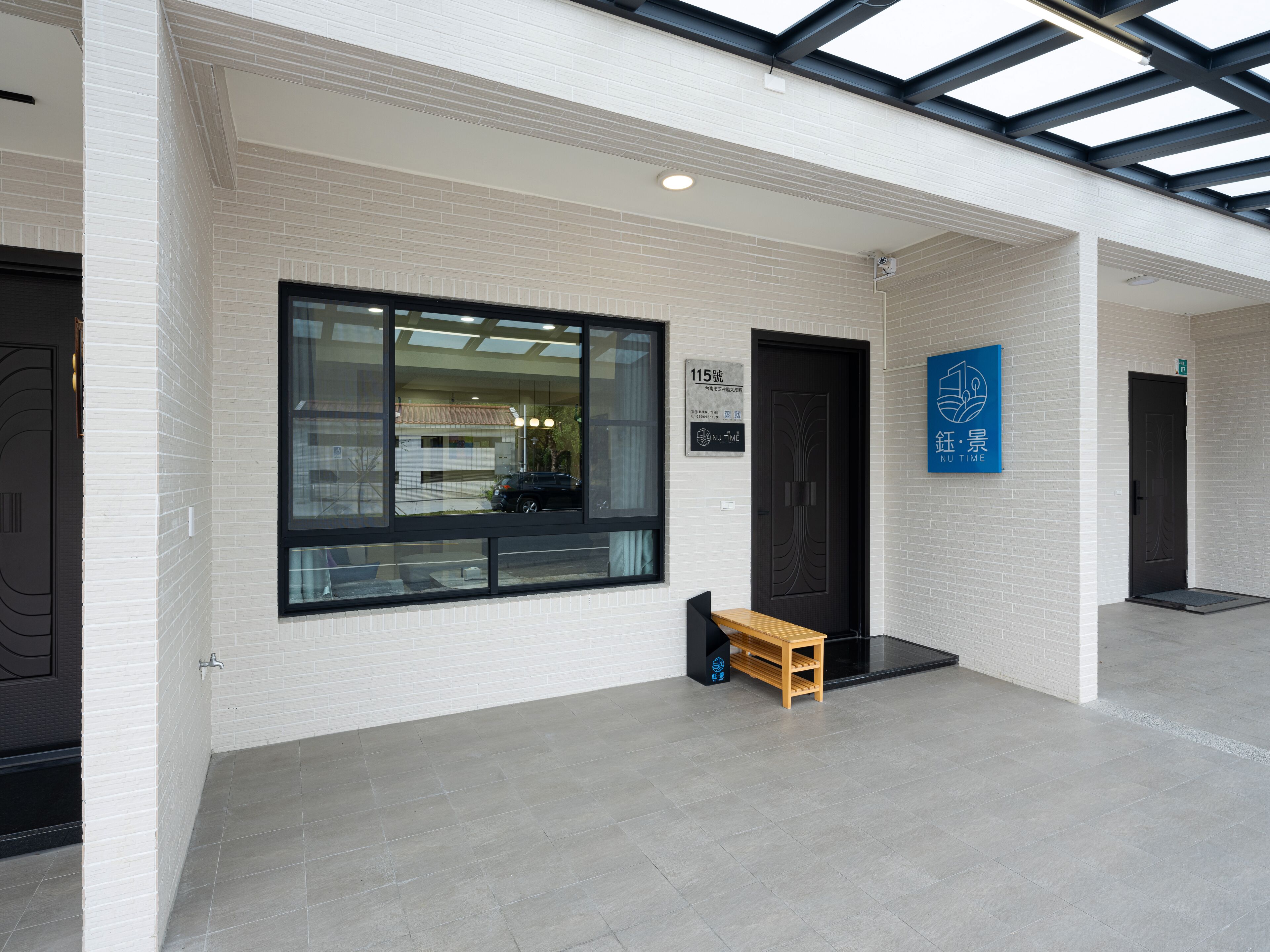 A modern building with a large window, a bench, and a door.