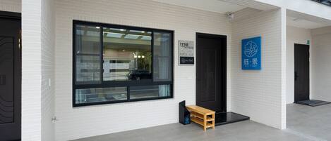 A modern building with a large window, a bench, and a door.