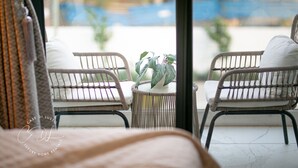 A balcony with wicker chairs and a small table with a plant. - Casse Di Lusso  (Accra)