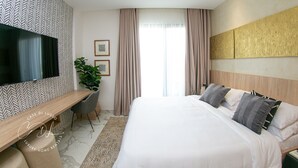 A modern hotel room with a large bed, a desk, a flat-screen TV, and a large window with curtains. - Casse Di Lusso  (Accra)