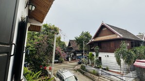 A residential area with a wooden house marked '2009', a parked car, and a white fence. - Villa Thida Mekong Riverside (Luang Prabang)
