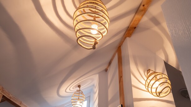 A ceiling with two spiral light fixtures and exposed wooden beams. - Bohemian Guest House (Sofia)