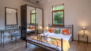 A bedroom with a bed, bedside tables, a mirror, and a window. - Bohemian Guest House (Sofia)