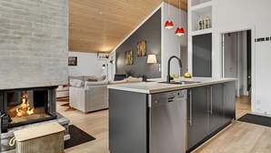 Una cucina moderna con isola centrale, lavastoviglie integrata e rubinetto nero.