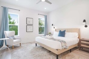 A bedroom with a bed, bedside tables, a chair, and a window with curtains.