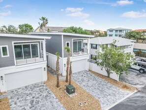 A modern residential area with houses featuring large windows, a garage, and a paved driveway.