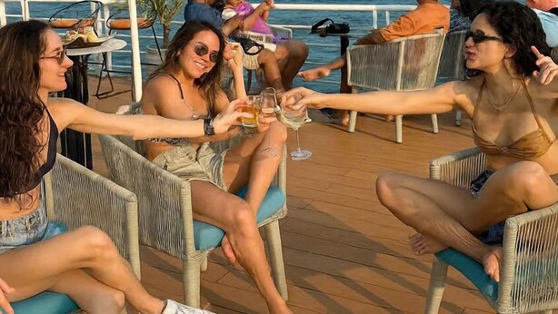 A group of people sitting on wicker chairs on a wooden deck overlooking the sea. -  Omina Hanoi Hotel and Restaurant  (Hanoi)