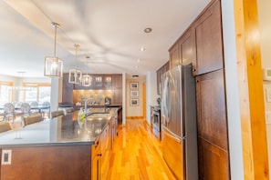 A modern kitchen with a central island, stainless steel appliances, and pendant lighting.