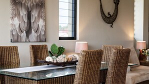 A dining area with wicker chairs, a glass table, and a decorative centerpiece. - Villa Sangiovese - Unit One - 1-2 Heath Street (Evans Head)