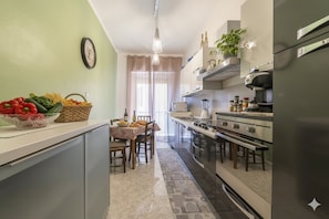 Una cocina compacta con comedor, que incluye estufa, horno y varios electrodomésticos.