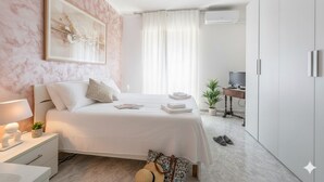 Una camera da letto moderna con un letto grande, un comodino e una scrivania con una sedia.