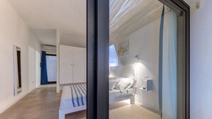 Une chambre à coucher moderne avec un lit, un banc et une armoire.