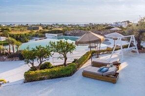 Area piscina con sedie a sdraio e vista sul mare.