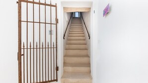 A staircase leading to a room with a metal gate and a sign on the wall. - Masseria Samenti - Suite Turchese with sea view (Torre Suda)