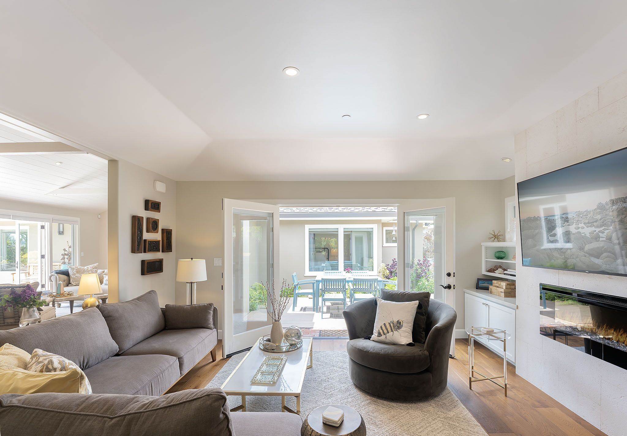 A modern living room with a grey sofa, a black armchair, a coffee table, and a fireplace.
