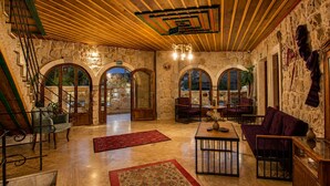 A spacious lobby with stone walls, arched doorways, and a wooden ceiling. - Premium Cappadocia Hotel (Nevsehir)