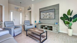 A modern living room with a fireplace, comfortable seating, and a large plant. - Azure Paradise | Canal View | Dock | 2 Masters | Spa (Port Charlotte)