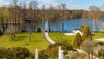 Relax in a serene outdoor setting surrounded by lush greenery and a tranquil body of water.
