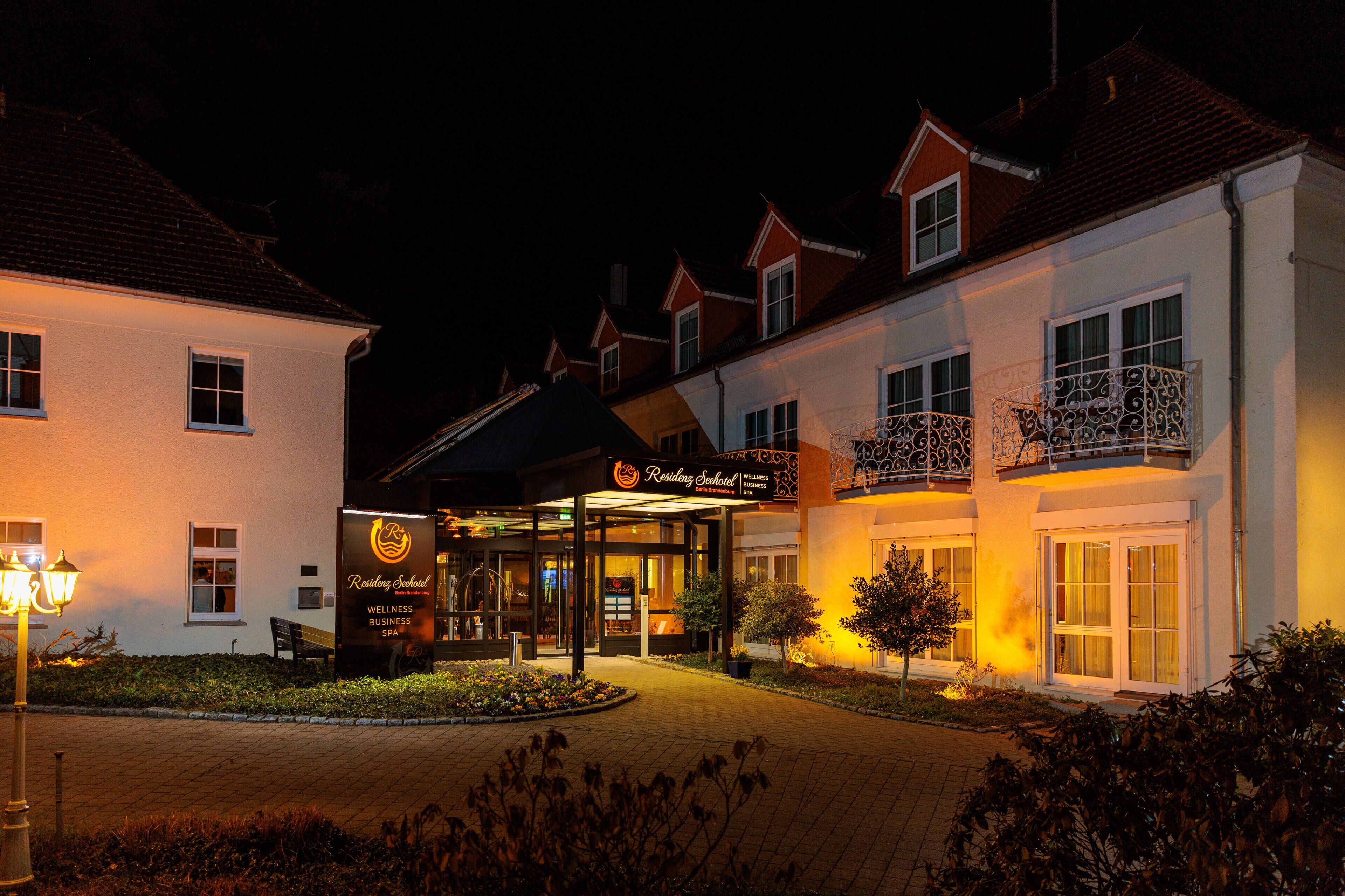 A well-lit hotel entrance with a sign for 'Resting School Wellness Business Spa'.