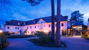 A large, two-story building with a well-lit entrance and a sign for Reading School. - Residenz Seehotel Berlin Brandenburg (Mittenwalde)