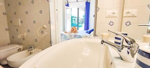 Une salle de bain équipée d’une baignoire, de toilettes et d’un bidet.